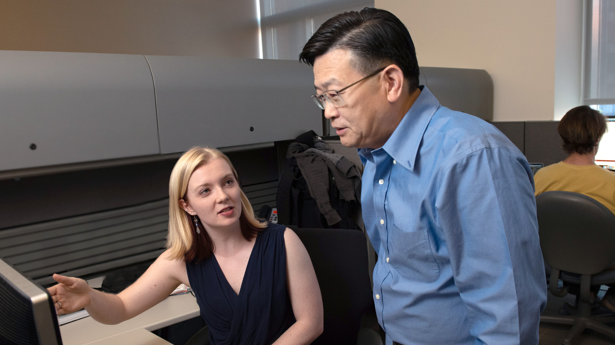 Emily Jones and Yadong Huang talking in front of a computer