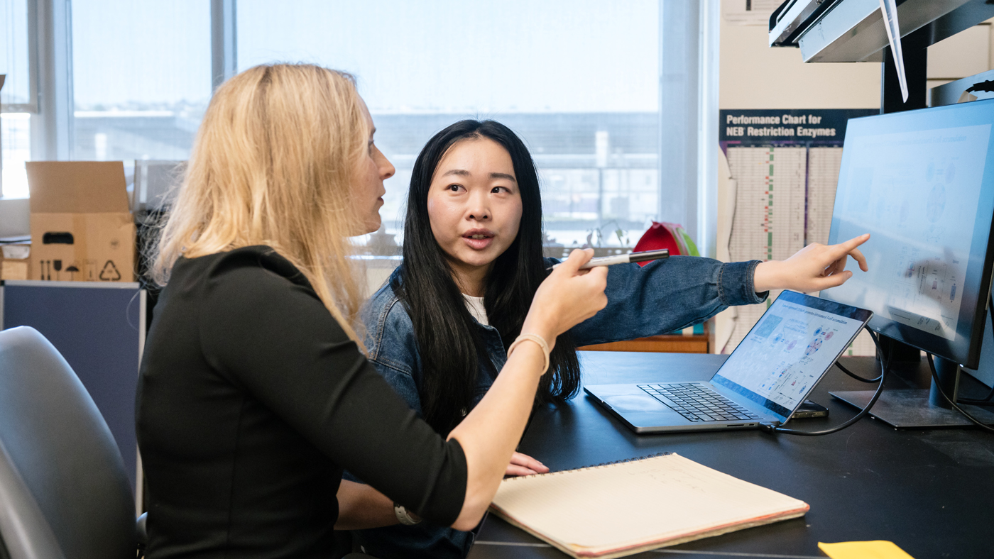 Qi Liu speaking with Julia Carnevale in the lab at Gladstone Institutes