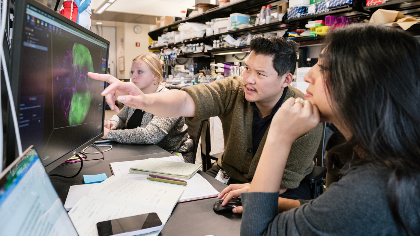 Andrew Yang and Nalini Rao looking at a monitor in the lab at Gladstone Institutes