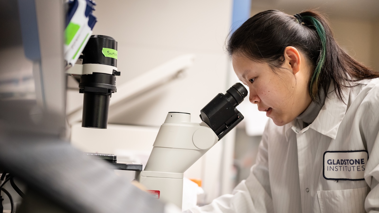 a woman looking through a microscope