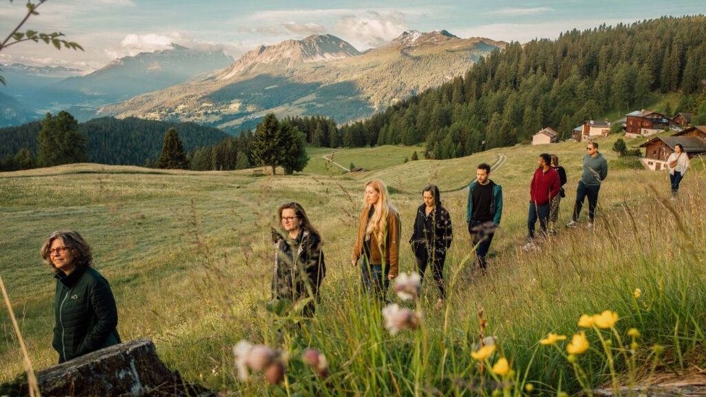 A group hikes in Switzerland with mountains in the background