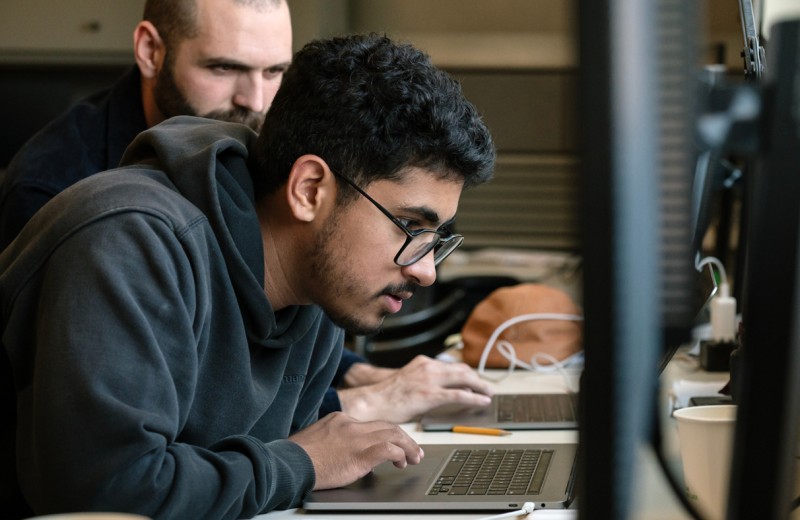 PUMAS intern working with his mentor at a laptop