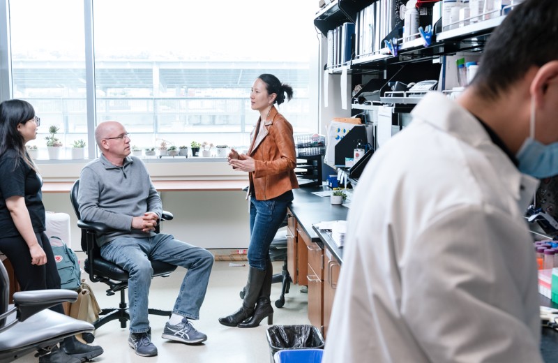 Nadia Roan talking to two researchers in the lab