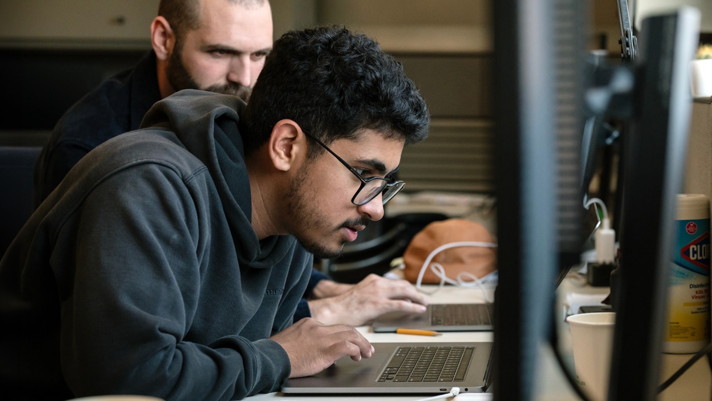 PUMAS intern working with his mentor at a laptop