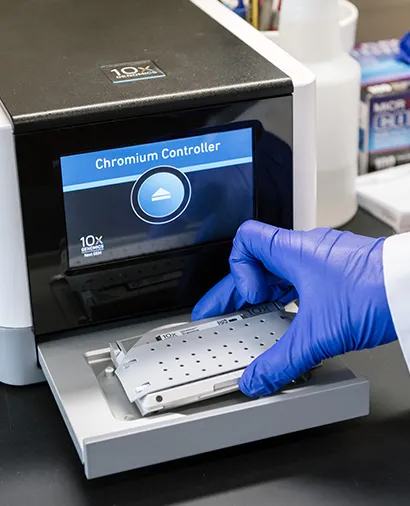 Close up of hands loading a piece of lab equipment