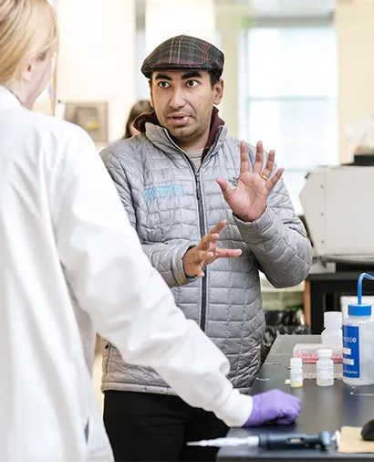 Sukrit silas speaking to another scientist who is facing away from the camera