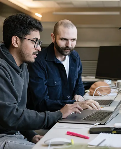 Two scientists working together on a computer in the Theodoris lab.