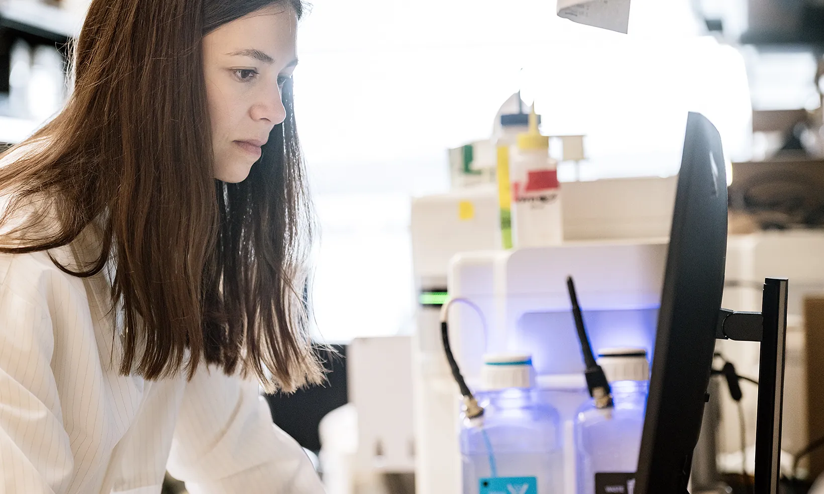 Close up of a scientist working on a computer at a lab bench