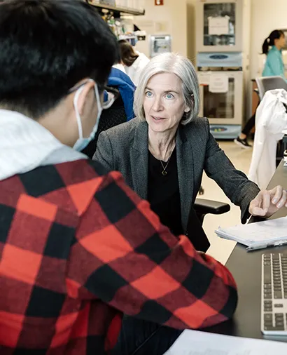 Jennifer Doudna speaking to another scientist in the lab