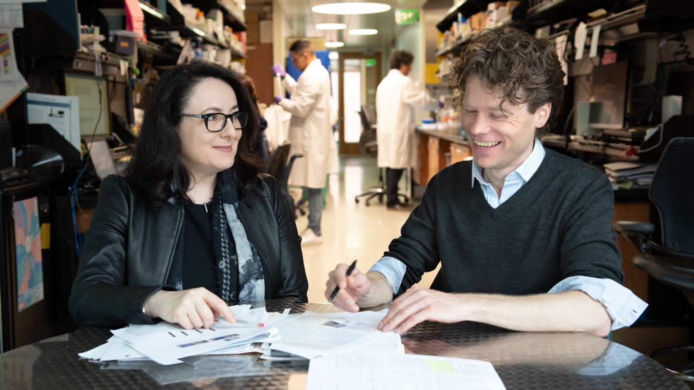 Katerina Akassoglou and Mario Merlini sitting at a table discussing their work