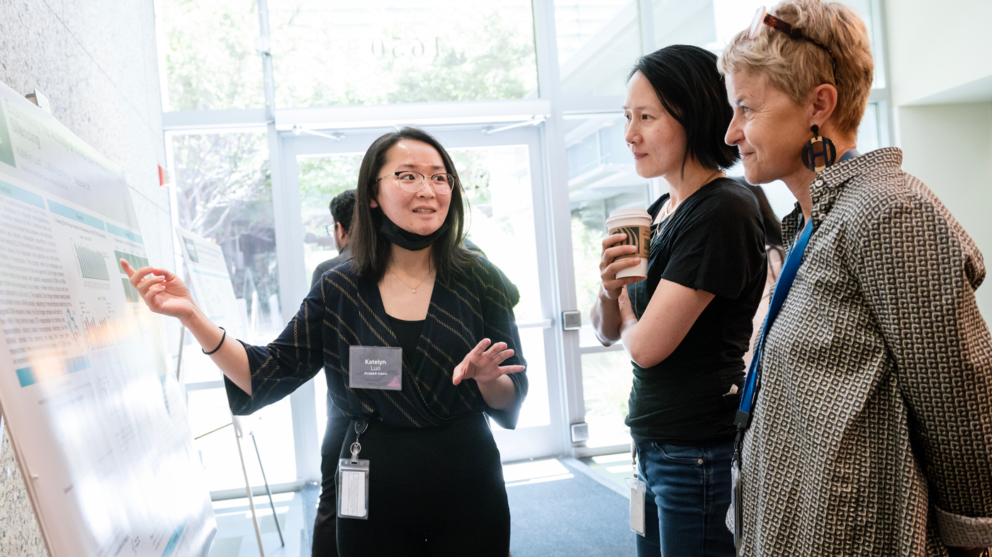 A PUMAS intern explains her research project at the poster session.