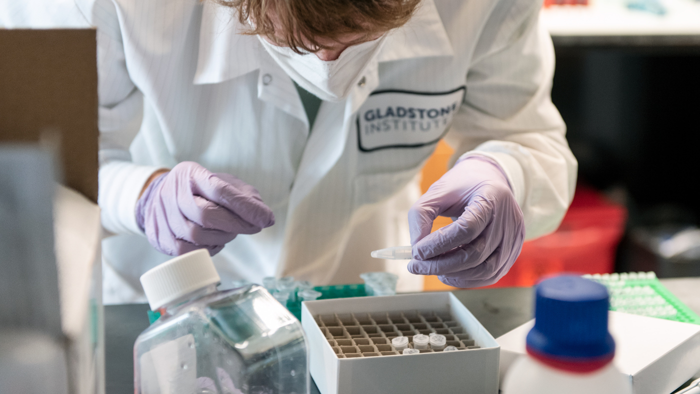 masked scientist working at a lab bench