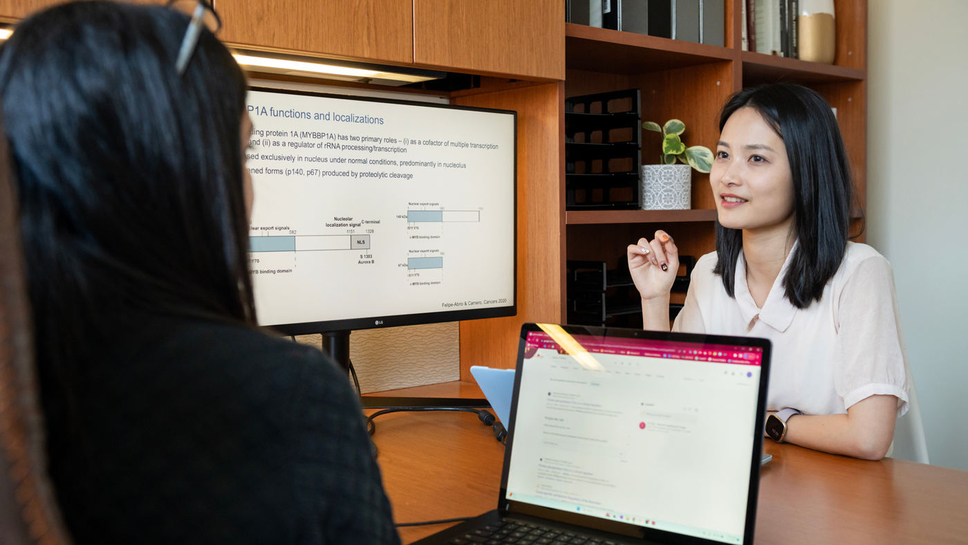 Graduate Student Kirsten Xuewen Chen speaking with Gladstone Investigator Isha Jain