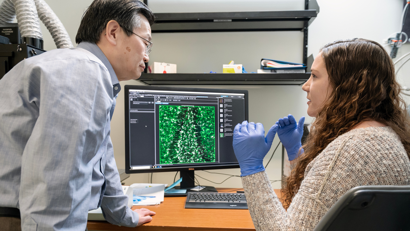 Researcher Nicole Koutsodendris speaking with Gladstone Investigator Yadong Huang