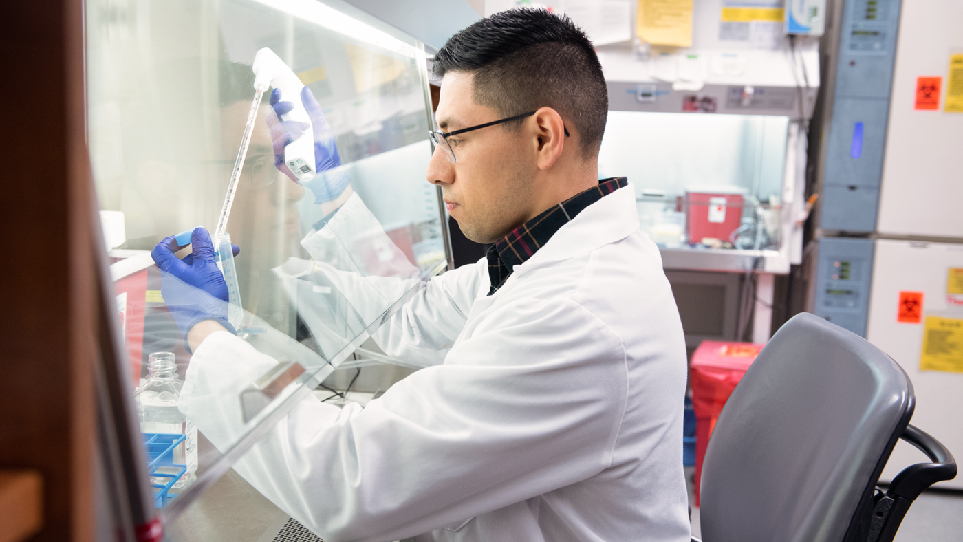 Postdoc Andrew Mendiola working in the lab at Gladstone Institutes