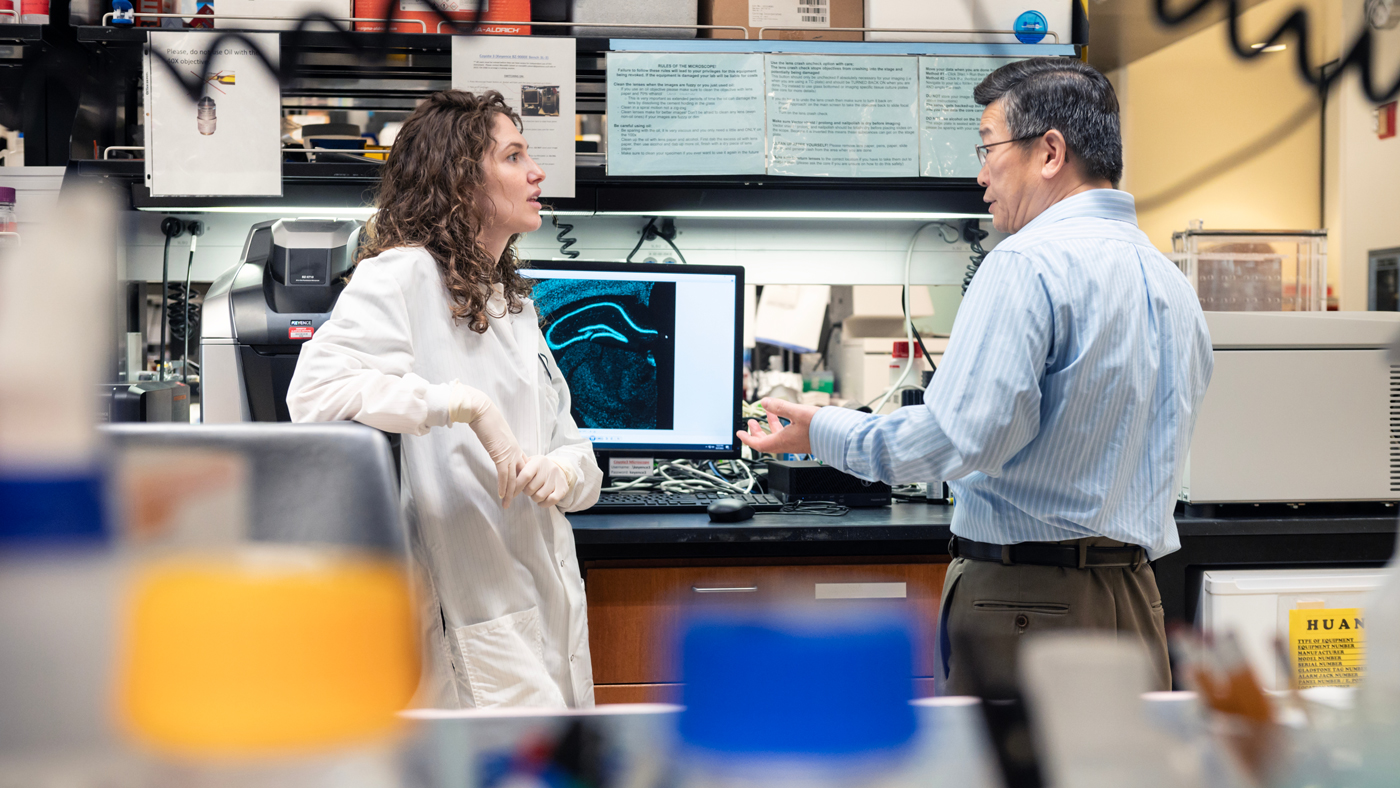 Maxine Nelson and Yadong Huang talking in the lab