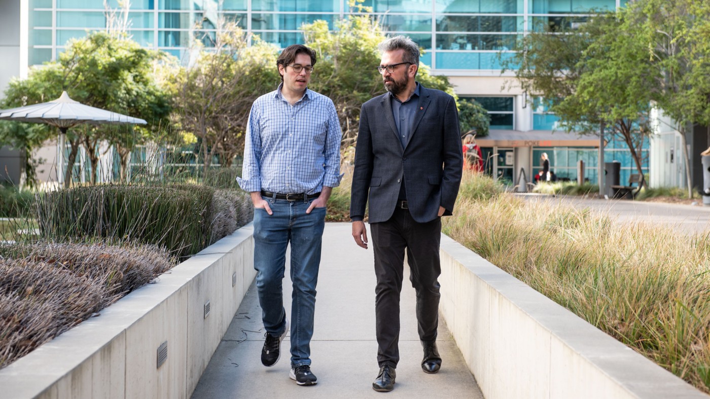 David Gordon and Nevan Krogan talking while walking in the Gladstone courtyard